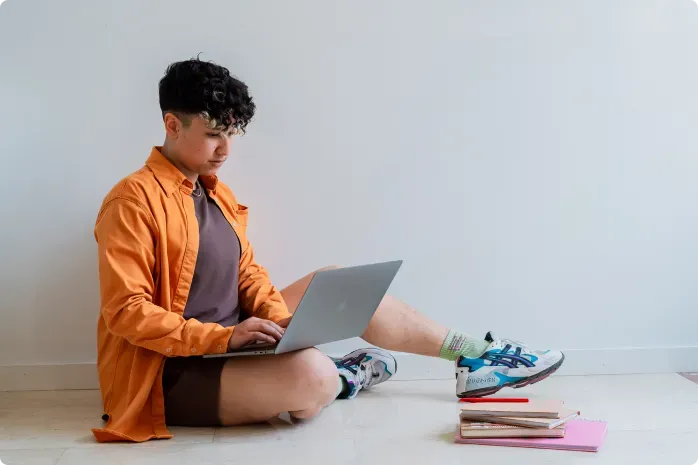 Rocio Sanchez, SEO specialist, sitting on the floor and working on their laptop