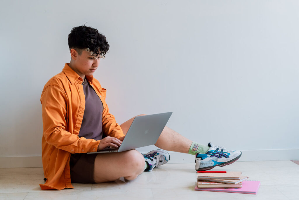 Marketing by Rocio founder and SEO specialist Rocio Sanchez using laptop and performing SEO while sitting down on the floor.