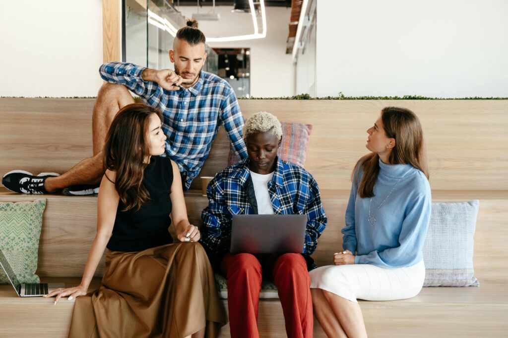 Employees discussing how to celebrate Pride Month in their workplace and how to improve LGBTQ+ inclusion in their workplace