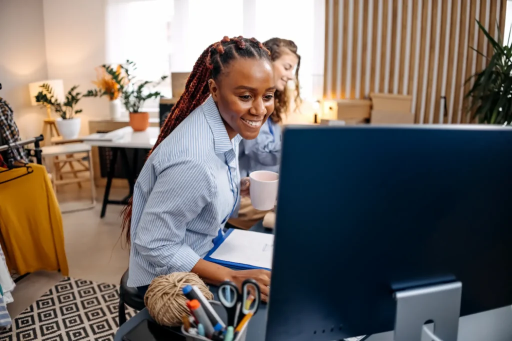Small business owner smiling while working on her website SEO at her desk.