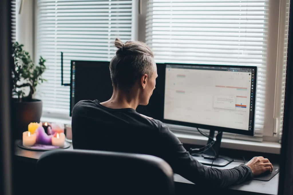Business owner sitting at a desk reviewing social media metrics on a desktop monitor