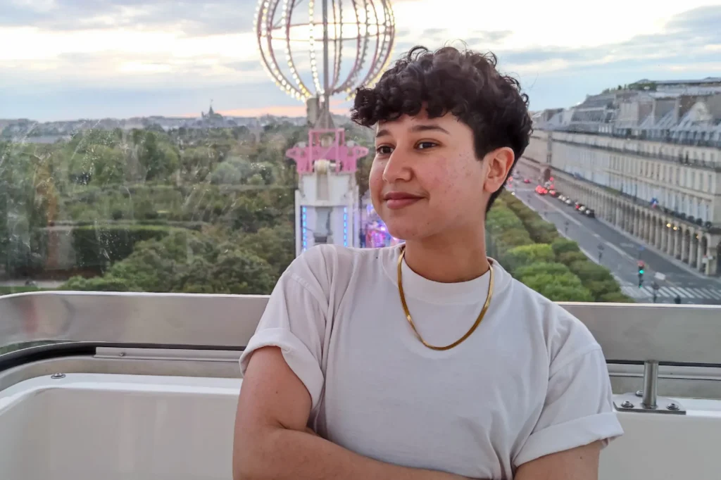 Marketing by Rocio founder looking to the side against an outdoor city and park backdrop.
