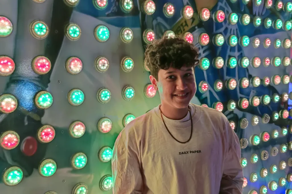 Marketing by Rocio founder Rocio Sanchez standing in front of a colorful wall of glowing red and green lights