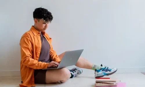 Rocio Sanchez, SEO specialist, sitting on the floor and working on their laptop